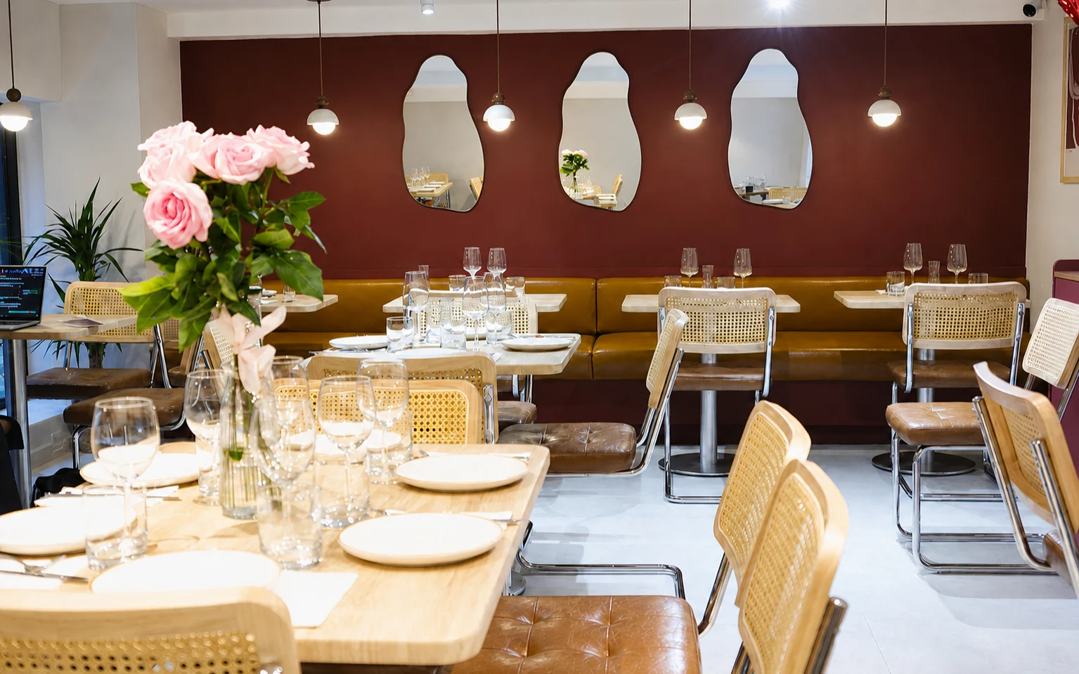 The full dining room — banquette, mirrors, pendant globes